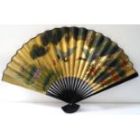 DECORATIVE CHINESE FAN of large size with ebonised sticks, the paper with a gold ground decorated