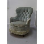 EDWARDIAN NURSING CHAIR with a shaped button back and arms above a circular seat, standing on