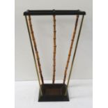 STICK STAND the two division top with bamboo and brass supports to a shaped drip pan, 50.5cm high