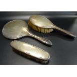 GEORGE V SILVER DRESSING TABLE SET comprising two brushes and a hand held mirror, each engraved '