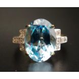 IMPRESSIVE BLUE TOPAZ AND DIAMOND DRESS RING the central oval cut blue topaz flanked by diamond
