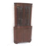 GEORGIAN STYLE MAHOGANY CORNER CABINET with a moulded dentil cornice above a pair of glazed doors,