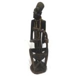 SIGNED CARVED AFRICAN WOODEN FIGURE of a story teller playing a three string Bolon seated on a