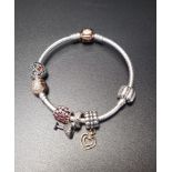 PANDORA MOMENTS SILVER CHARM BRACELET with rose clasp, four Pandora charms including an enamel