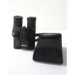 PAIR OF NIKON ACULON FIELD GLASSES with 10x25 magnification and rubber cased, with a canvas carry
