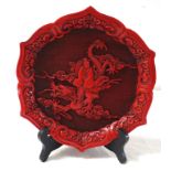 CINNABAR WALL PLAQUE with a shaped border decorated with scrolls around a central dragon with a