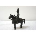 TIBETAN BRONZE OF A WARRIOR ON HORSEBACK clutching his raised sword, 16cm high