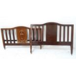 EDWARDIAN MAHOGANY DOUBLE BED with a shaped and slatted head and footboard, inlaid with floral