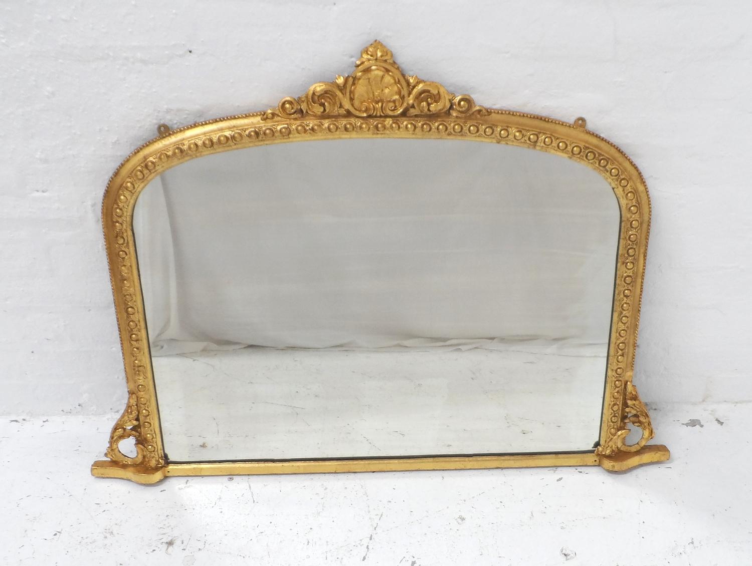 19th CENTURY GILTWOOD OVERMANTLE MIRROR with a central carved shell and scroll pediment above the