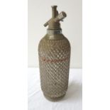 VINTAGE GLASS SODA SYPHON overlaid with a metal wirework lattice, 34.5cm high