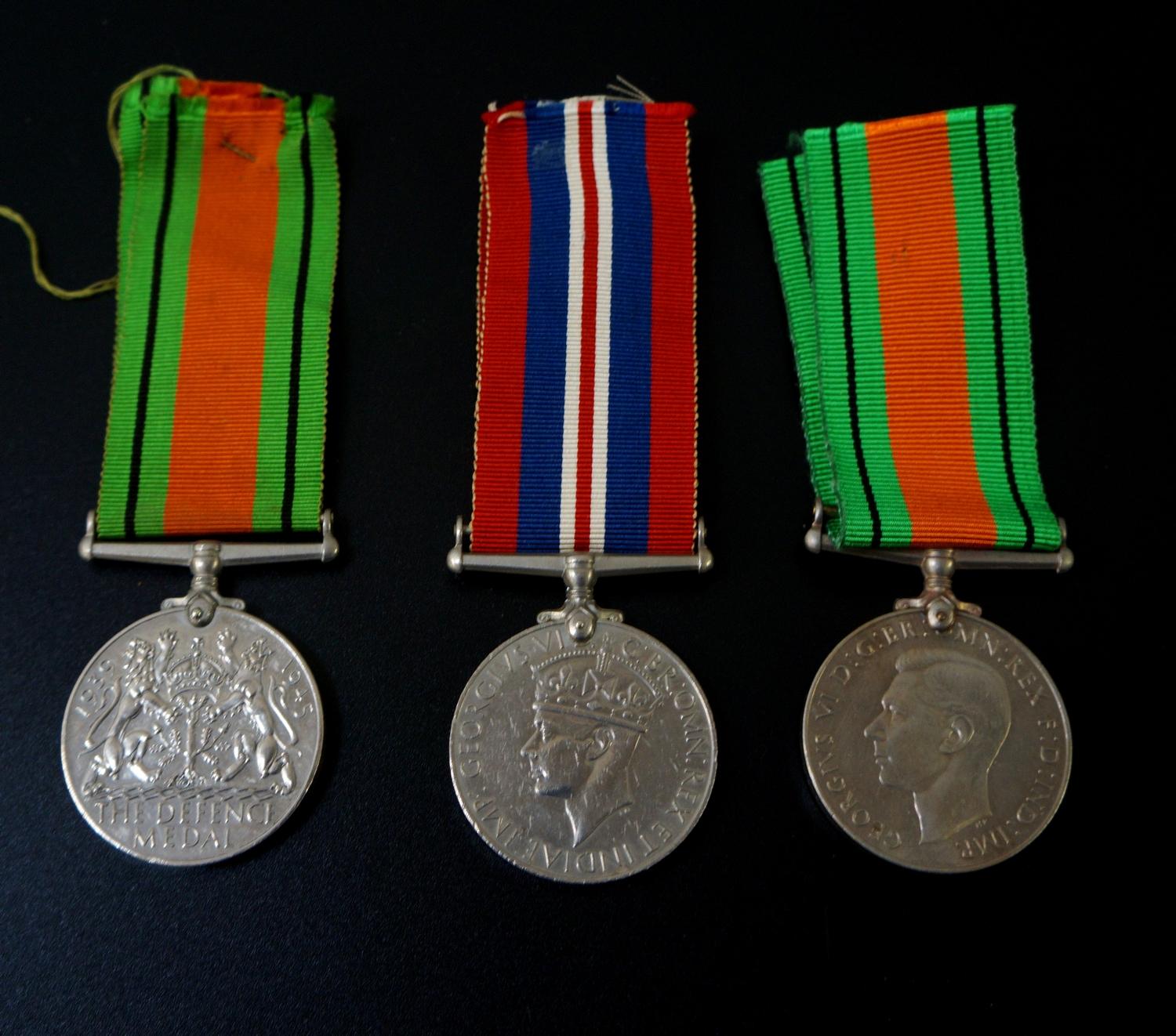 TWO WORLD WAR II GEORGE VI DEFENCE MEDALS with ribbons together with a World War II medal and ribbon