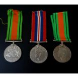 TWO WORLD WAR II GEORGE VI DEFENCE MEDALS with ribbons together with a World War II medal and ribbon