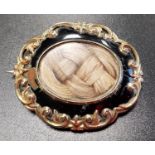 VICTORIAN ENAMEL DECORATED GOLD MOURNING BROOCH the central glazed panel revealing entwined hair,