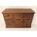 STAINED PINE SIDE CABINET with a plank top above three panelled frieze drawers with three panelled