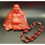 CHINESE CINNABAR LACQUER BUDDHA seated holding a scroll and beads, 10.5cm high; together with a
