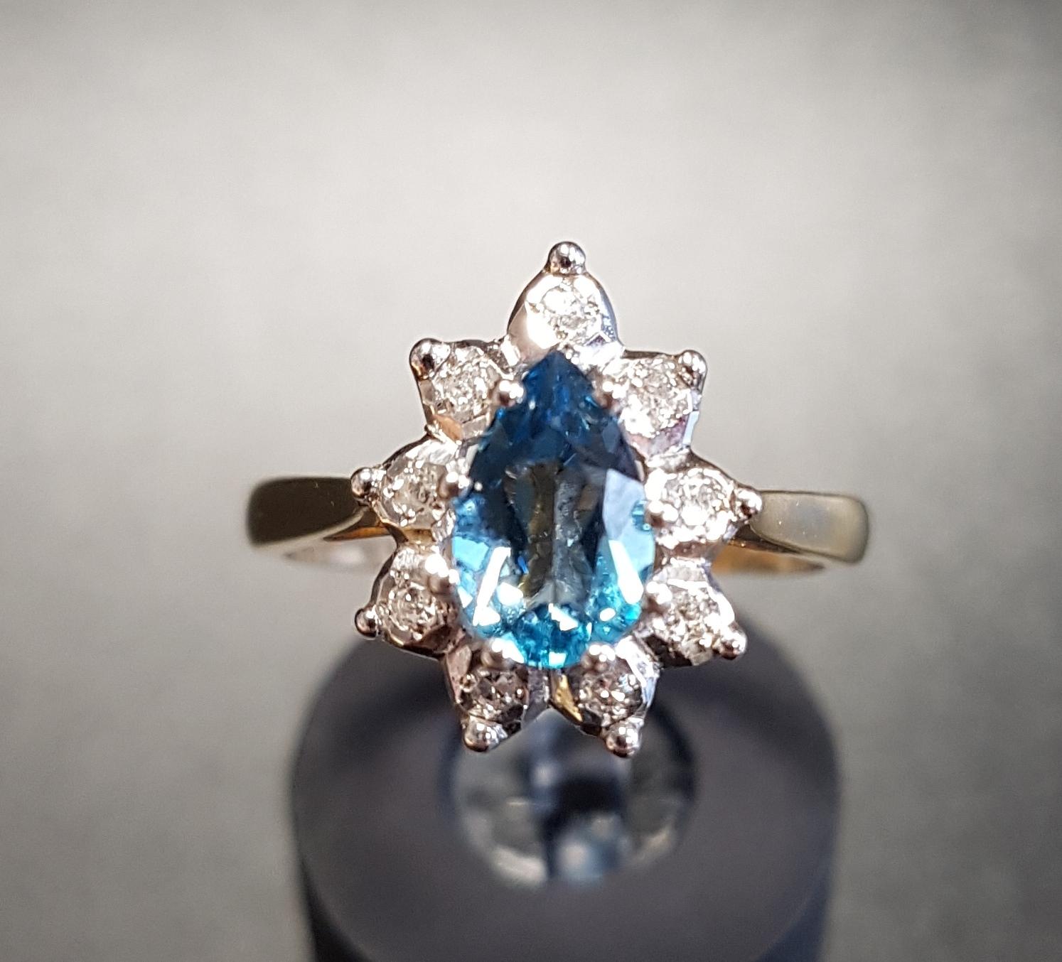 BLUE TOPAZ AND DIAMOND CLUSTER RING the central pear cut topaz in nine diamond surround, on nine