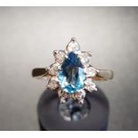BLUE TOPAZ AND DIAMOND CLUSTER RING the central pear cut topaz in nine diamond surround, on nine