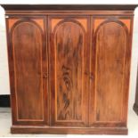 EDWARDIAN MAHOGANY AND INLAID WARDROBE with a moulded top above three inlaid arched panelled doors