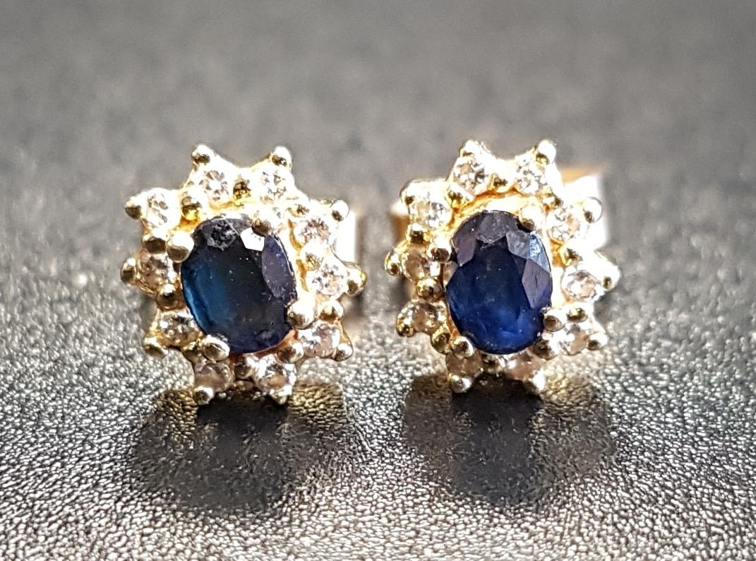 PAIR OF SAPPHIRE AND DIAMOND CLUSTER STUD EARRINGS the central oval cut sapphire on each in ten