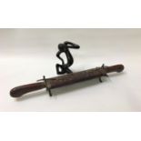 INDIAN TEAK CARVING SET with a flattened carved oval body containing a carving knife and fork with