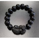 ONYX BEAD BRACELET comprising of fourteen circular beads and one carved dog of foe