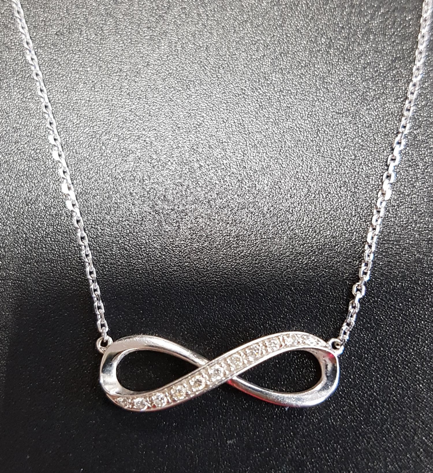 DIAMOND SET INFINITY SYMBOL PENDANT in nine carat white gold and on attached nine carat white gold