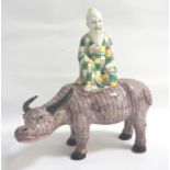 CHINESE PORCELAIN FIGURE of an old man in brightly coloured robes seated on an ox, 27cm high