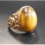 TIGER'S EYE DRESS RING the central oval cabochon tiger's eye flanked by relief scroll decorated
