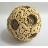 VERY LARGE CHINESE IVORY PUZZLE BALL with profuse carved dragon decoration, the interior spheres