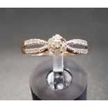 DIAMOND CLUSTER RING the central cluster flanked by diamond set split shoulders, on nine carat