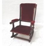 MAHOGANY LOW ROCKING CHAIR with a shaped padded back, arms and seat with decorative stud detail