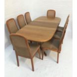 TEAK EXTENDING DINING TABLE with a pull apart top opening to reveal a fold out leaf, standing on