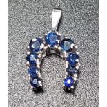 GRADUATED SAPPHIRE HORSESHOE BROOCH in eight carat white gold