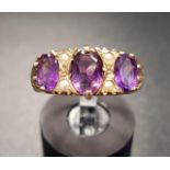 AMETHYST AND SEED PEARL RING the three graduated oval cut amethysts separated by small seed