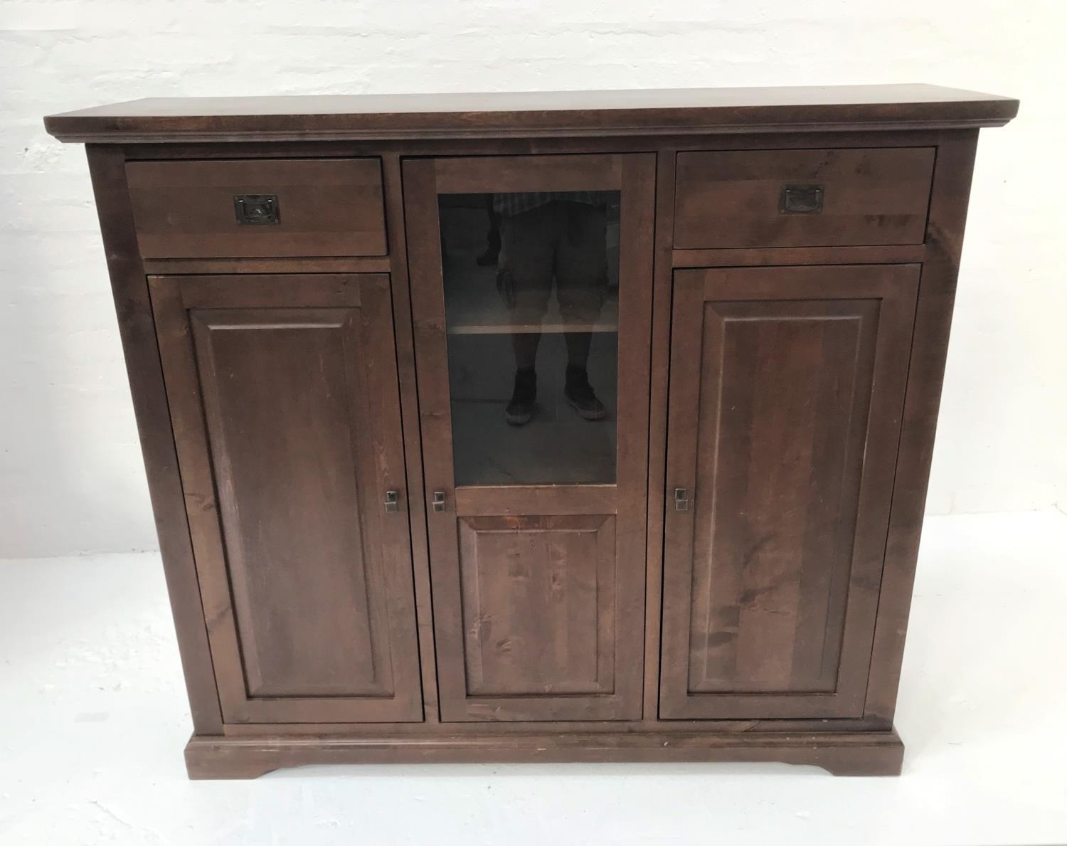 STAINED TEAK SIDE CABINET with a plain top above two frieze drawers with recessed handles flanking a