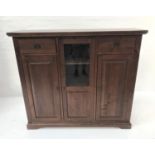 STAINED TEAK SIDE CABINET with a plain top above two frieze drawers with recessed handles flanking a