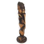 CARVED WEST AFRICAN FIGURE OF A MUSICIAN or story teller, playing a Bolon, raised on a shaped