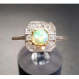 OPAL AND DIAMOND CLUSTER DRESS RING the central round cabochon opal in fourteen diamond surround, on