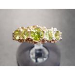 PERIDOT FIVE STONE RING on nine carat gold shank, ring size M