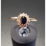 SAPPHIRE AND DIAMOND CLUSTER RING the central oval cut sapphire in fourteen diamond surround, on