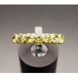 PERIDOT SEVEN STONE RING on nine carat gold shank, ring size N-O