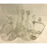 SEVEN CRYSTAL AND CUT GLASS DECANTERS of various sizes and designs, including a tall conical glass
