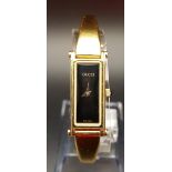 LADIES GUCCI 1500 WRISTWATCH the gold plated watch with black rectangular dial, the hinged