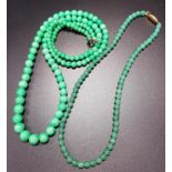 TWO JADE COLOURED HARDSTONE BEAD NECKLACES both of graduated form, 40cm and 81cm long (2)