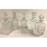 FIVE CRYSTAL DECANTERS all with cut decoration and stoppers, four square examples and one