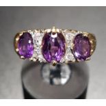 AMETHYST AND DIAMOND DRESS RING the three graduated oval cut amethysts separated by small