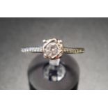 DIAMOND SOLITAIRE RING the round brilliant cut diamond approximately 0.2cts flanked by diamond set