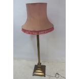 A BRASS STANDARD LAMP, with Corinthian capital and reeded column raised on a square stepped base,