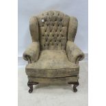 A DEEP BUTTONED UPHOLSTERED WING CHAIR,