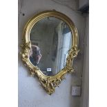 A CONTINENTAL GILT FRAMED MIRROR of cartouche outline the plate molded with figures with lattice